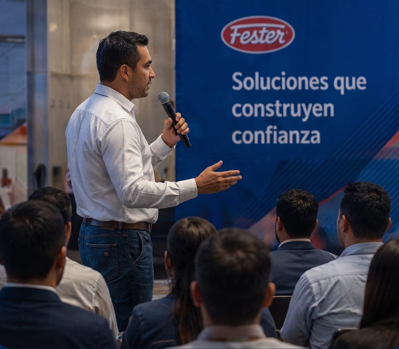 Conferencista con micrófono frente al público en un evento Fester